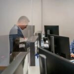 un homme est face au comptoir d'une hôtesse d'accueil dans une entreprise