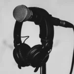 photo noir et blanc d'un pied de micro avec un casque posé dessus
